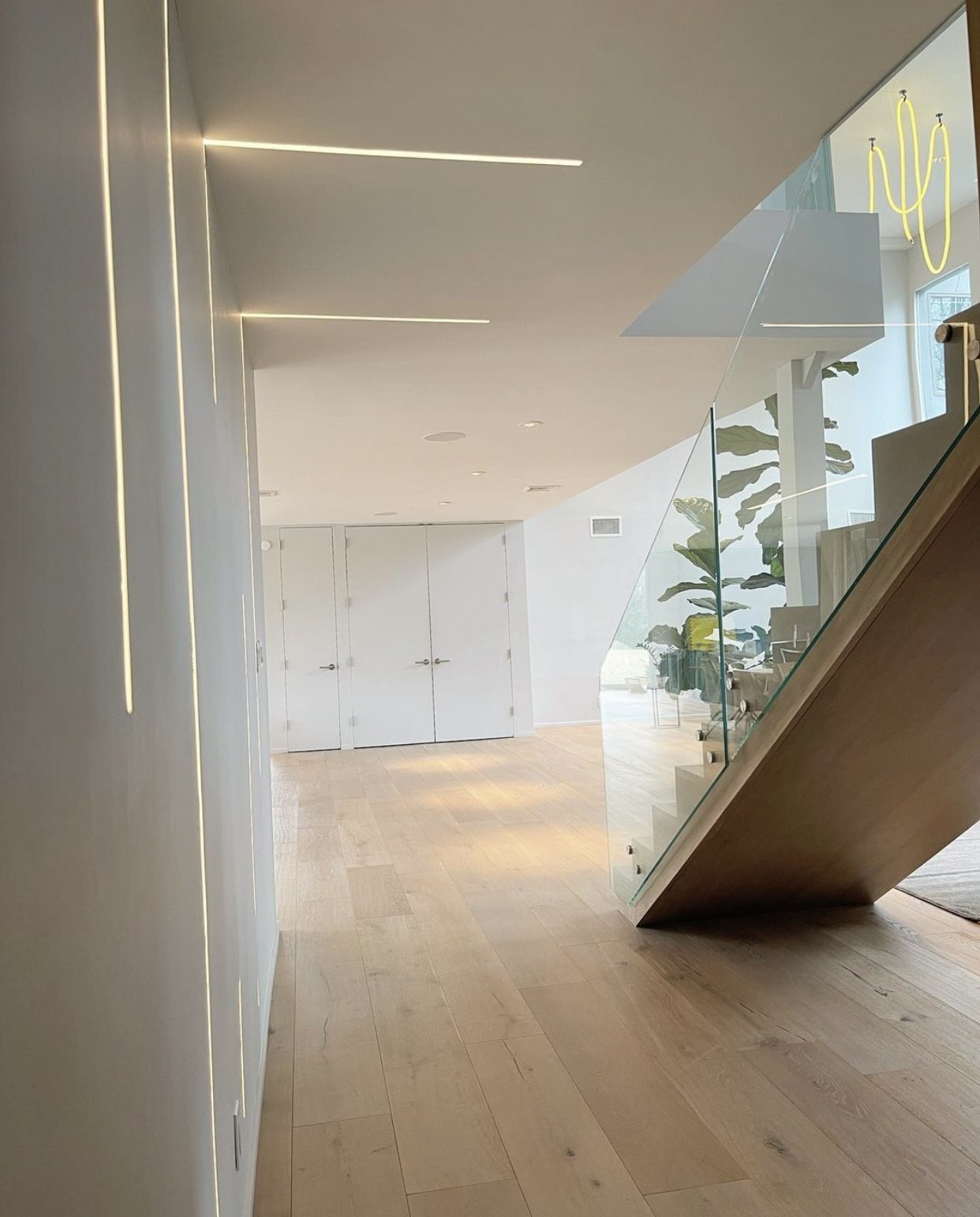 Architectural wall and ceiling lighting beside a timber staircase, installed by Elite Electrical